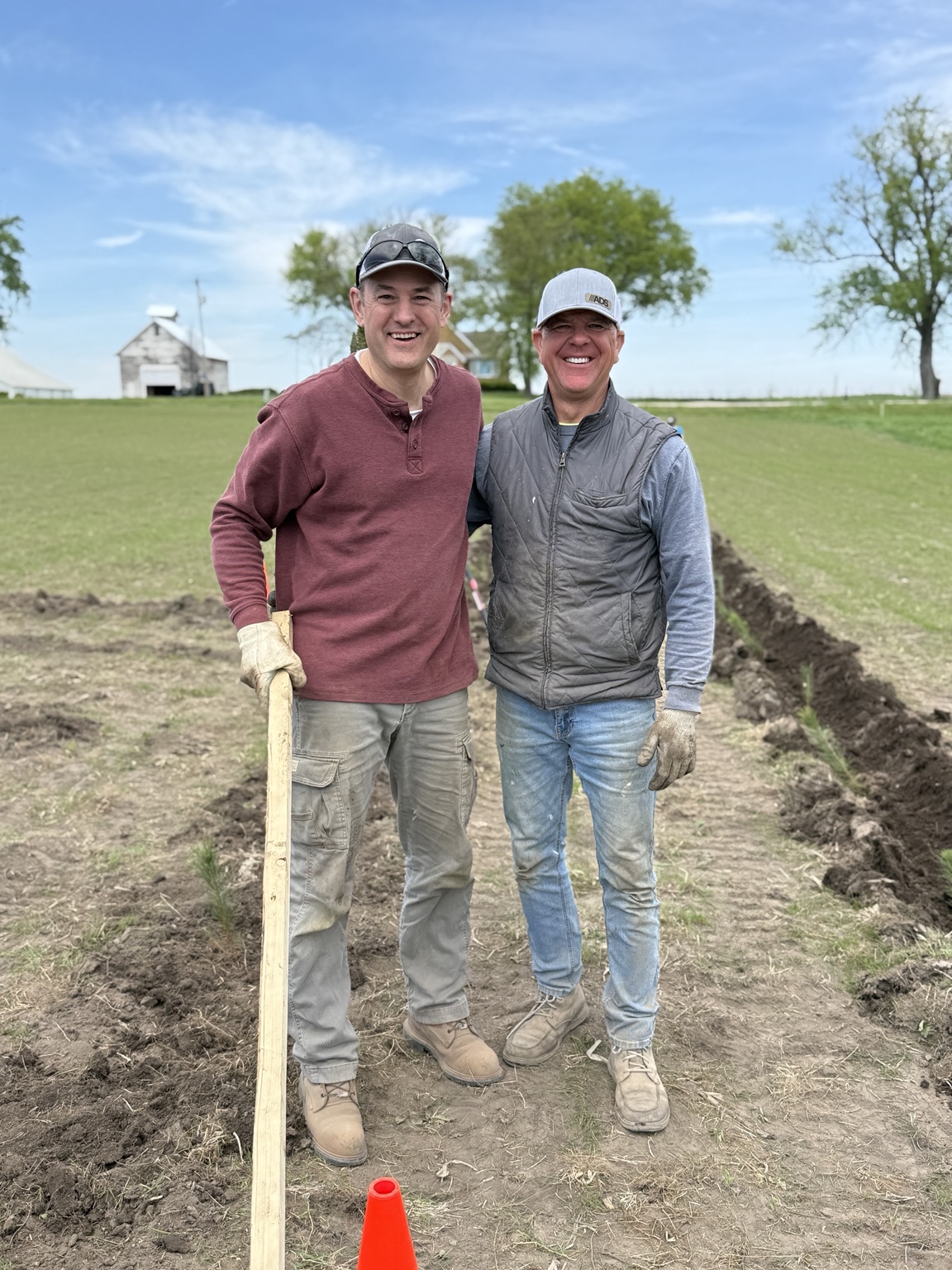 Scott and Connor Cofoid standing in the field beside newly dug planting rows